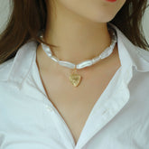 Necklace with a heart-shaped pendant on a mannequin wearing a white shirt.
