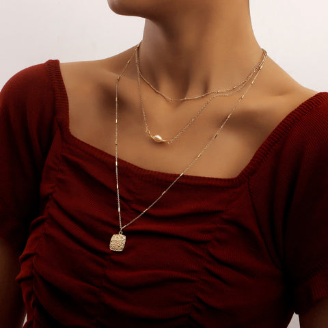 Woman Wearing Multilayer Spider Web Pearl Square Pendant Necklace - Glöd of Sweden